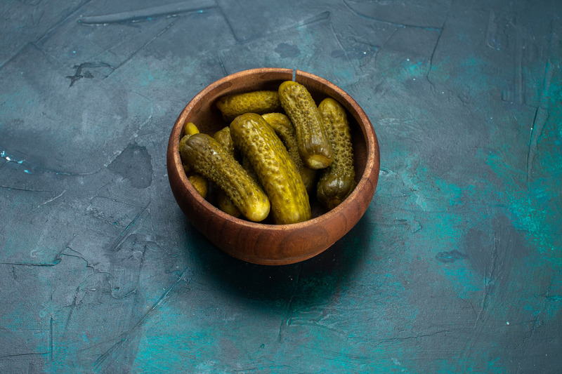 half-top-view-salty-pickles-inside-round-brown-pot-dark-blue-desk (1).jpg